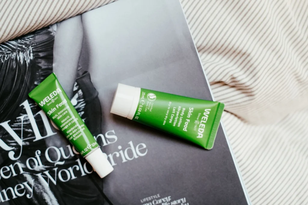 Two Weleda Skin Food tubes placed on a fashion magazine page.