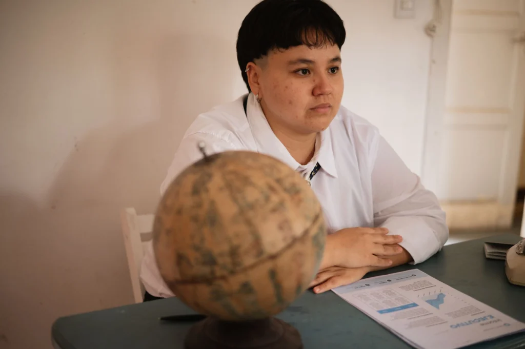 A focused student sits at a desk with a globe and documents, conveying study and exploration themes.
