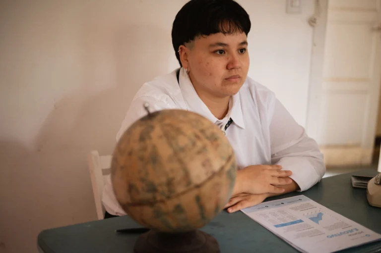 A focused student sits at a desk with a globe and documents, conveying study and exploration themes.