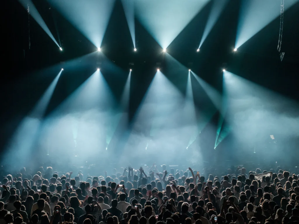 Stadium crowd under dramatic concert stage lighting, evoking a global performance like the 2026 World Cup closing ceremony