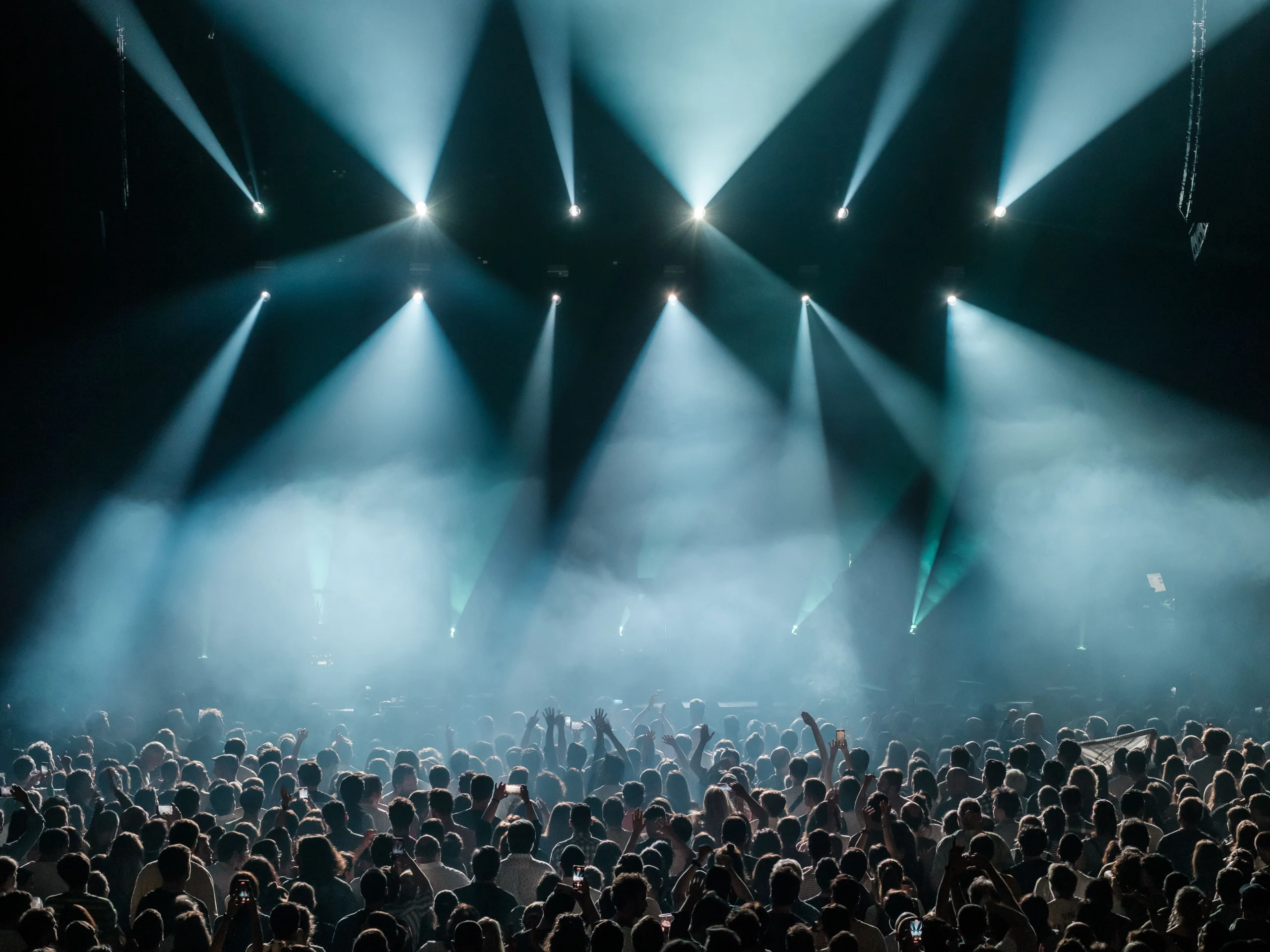 Stadium crowd under dramatic concert stage lighting, evoking a global performance like the 2026 World Cup closing ceremony
