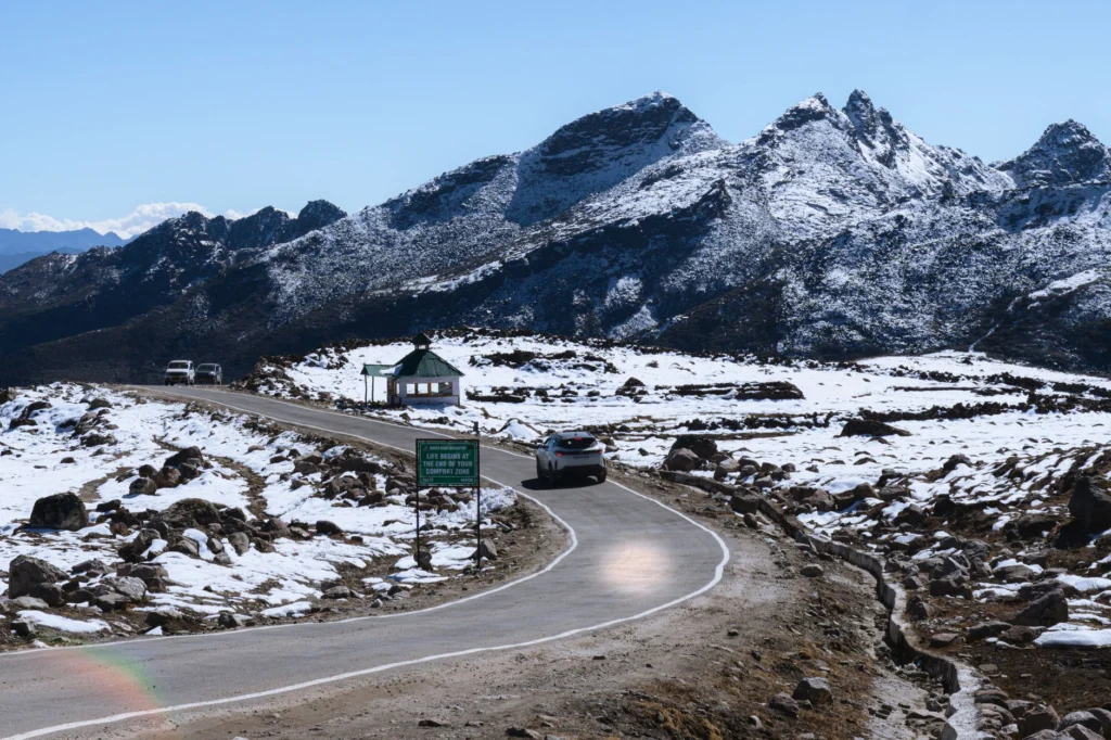 Breathtaking view of a winding road in a snowy mountainous landscape in Tawang, Arunachal Pradesh.