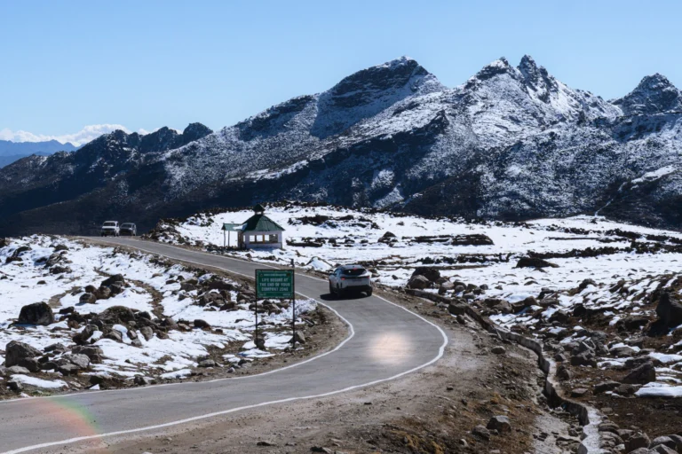 Breathtaking view of a winding road in a snowy mountainous landscape in Tawang, Arunachal Pradesh.