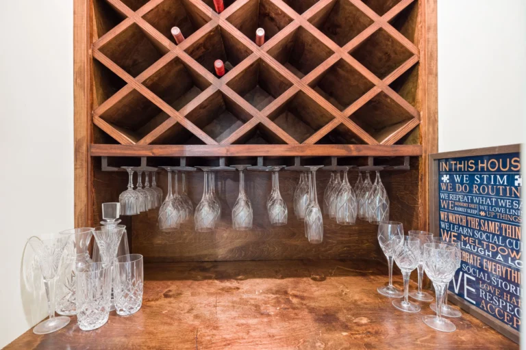 A stylish indoor wine rack with hanging glasses, showcasing elegant wine storage.