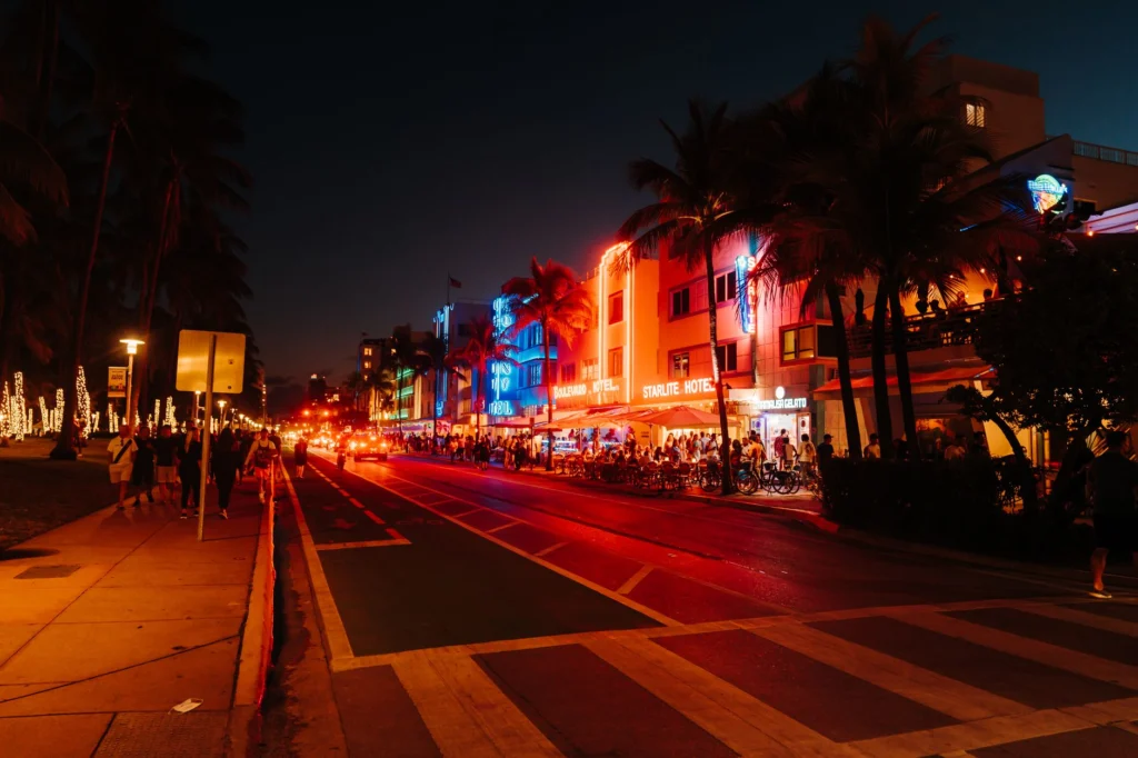 Lively Miami nightlife on Ocean Drive with illuminated Art Deco buildings and bustling streets.