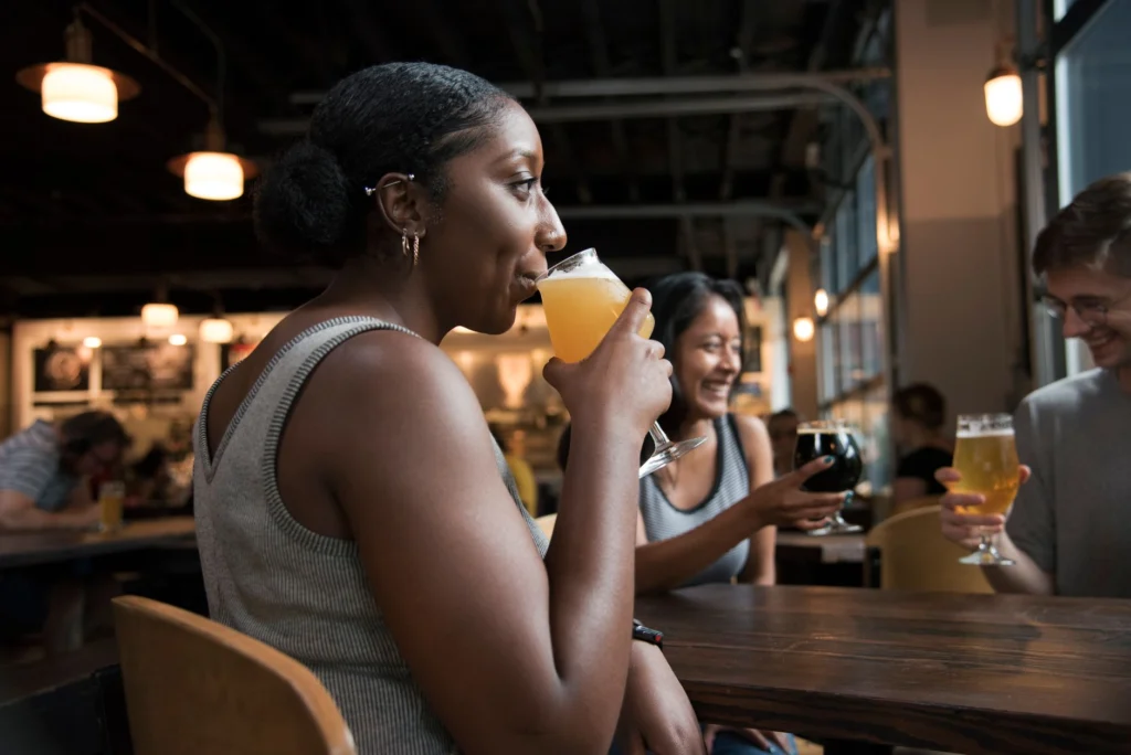 Group of friends having a good time sipping drinks in a cozy bar setting.