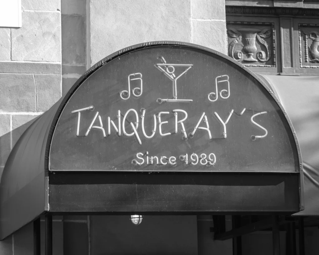 Monochrome image of a classic bar sign with martini glass and musical notes.