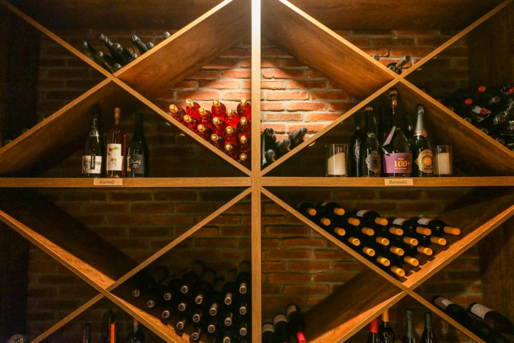 A beautifully organized wine cellar with wooden shelves displaying a variety of wine bottles.
