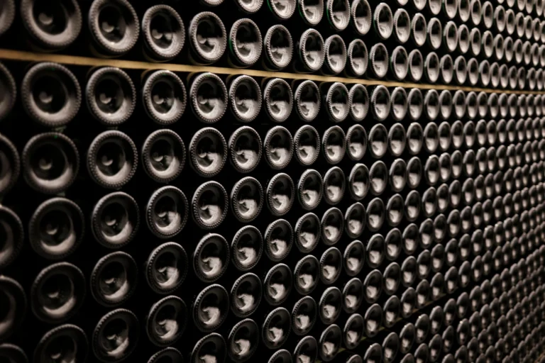 A close-up view of wine bottles stacked symmetrically in a wine cellar in Brussels, Belgium.