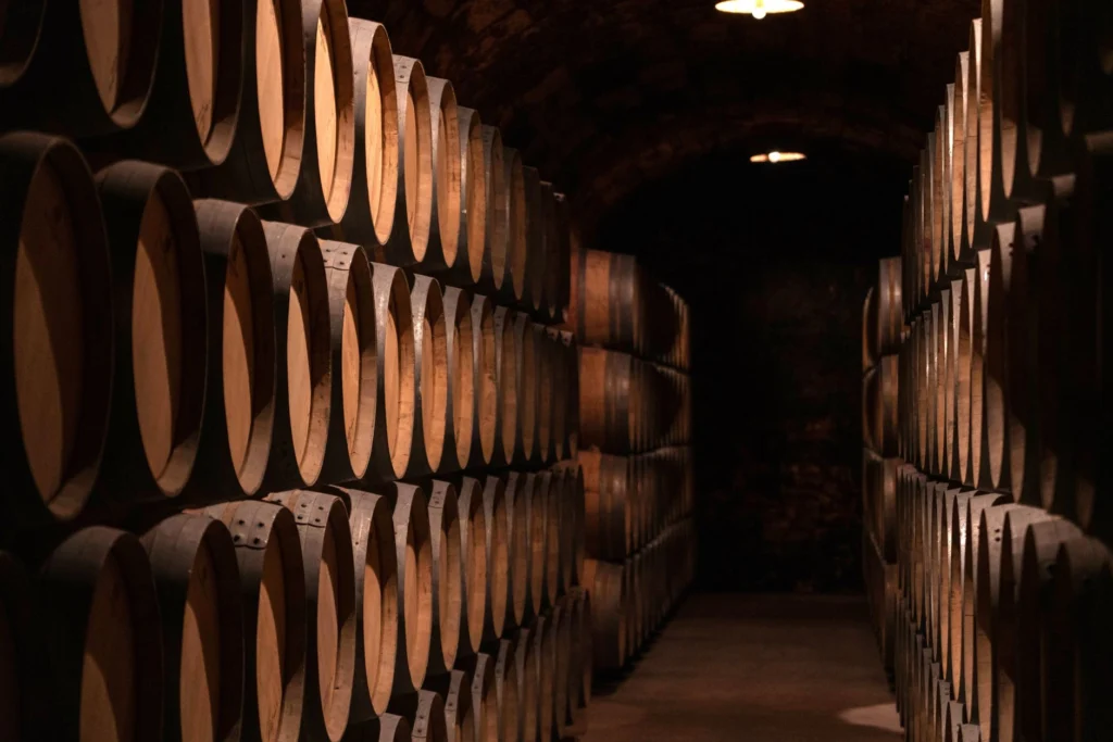 A dimly lit wine cellar filled with wooden barrels in an atmospheric setting.