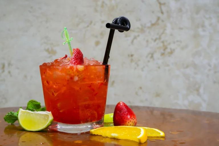 Delicious strawberry citrus cocktail with lime and mint on a wooden table. Perfect for summer refreshment.