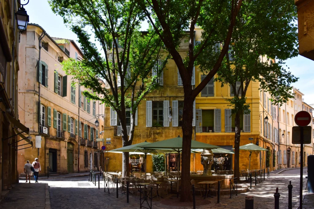 Picturesque street corner in Aix-en-Provence, showcasing traditional architecture and vibrant outdoor café setting.