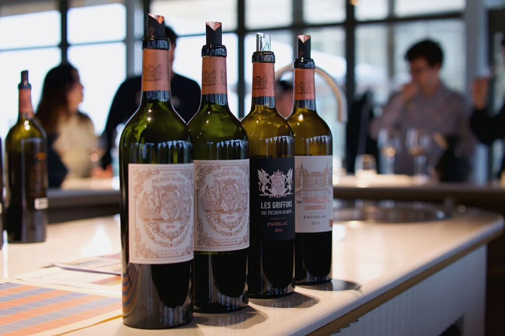 Showcase of elegant wine bottles from Pauillac, France, in a modern bar setting.