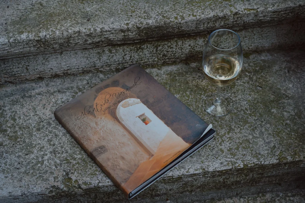 A photo book and wine glass on weathered stone steps create a rustic charm.