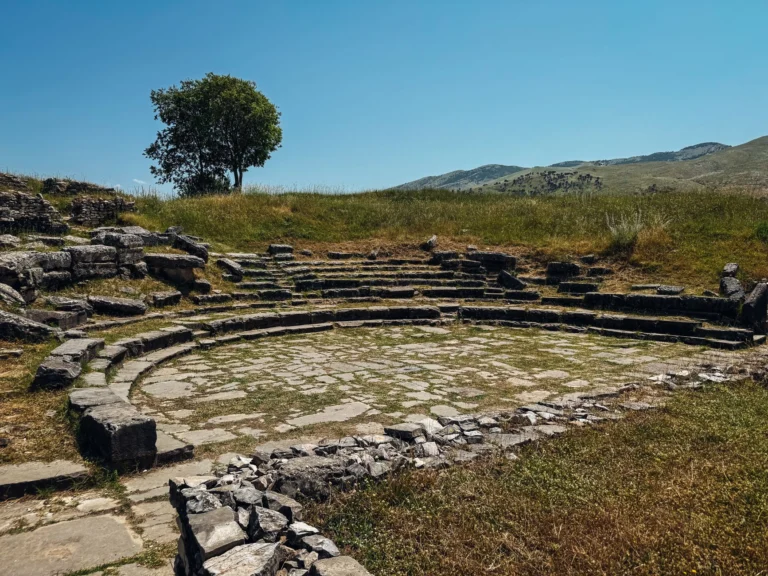 Scenic view of ancient amphitheater ruins surrounded by greenery in Albania.