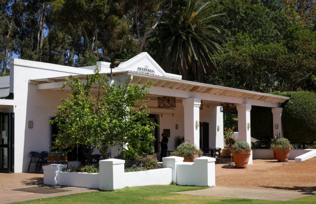 Charming colonial-style building with lush greenery on a sunny day.