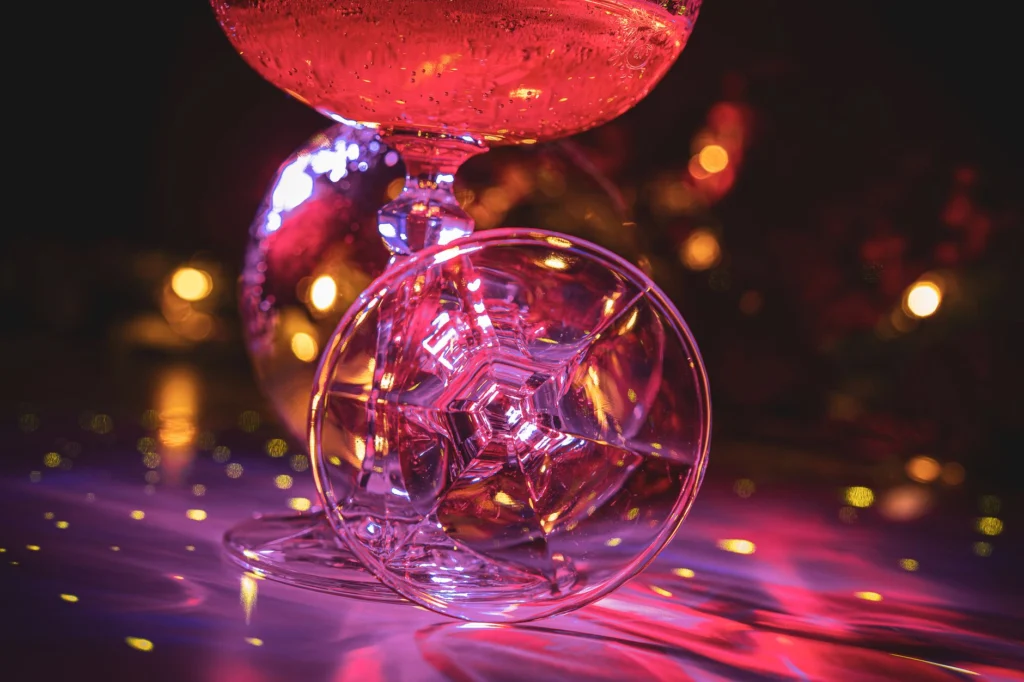 Vibrant champagne flutes with disco ball reflections evoke a festive party atmosphere.