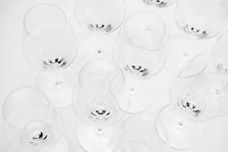 An artistic overhead shot showcasing a modern display of empty wine glasses on a white background.