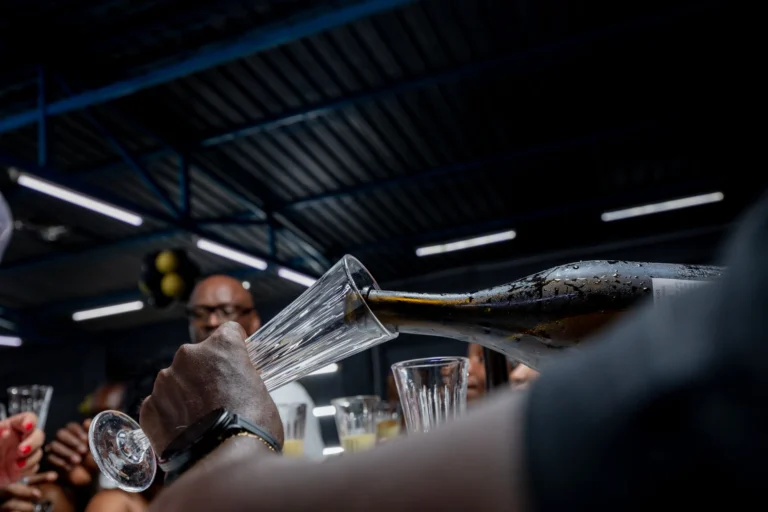 Close-up of champagne pouring into glasses at a festive event in Luanda.