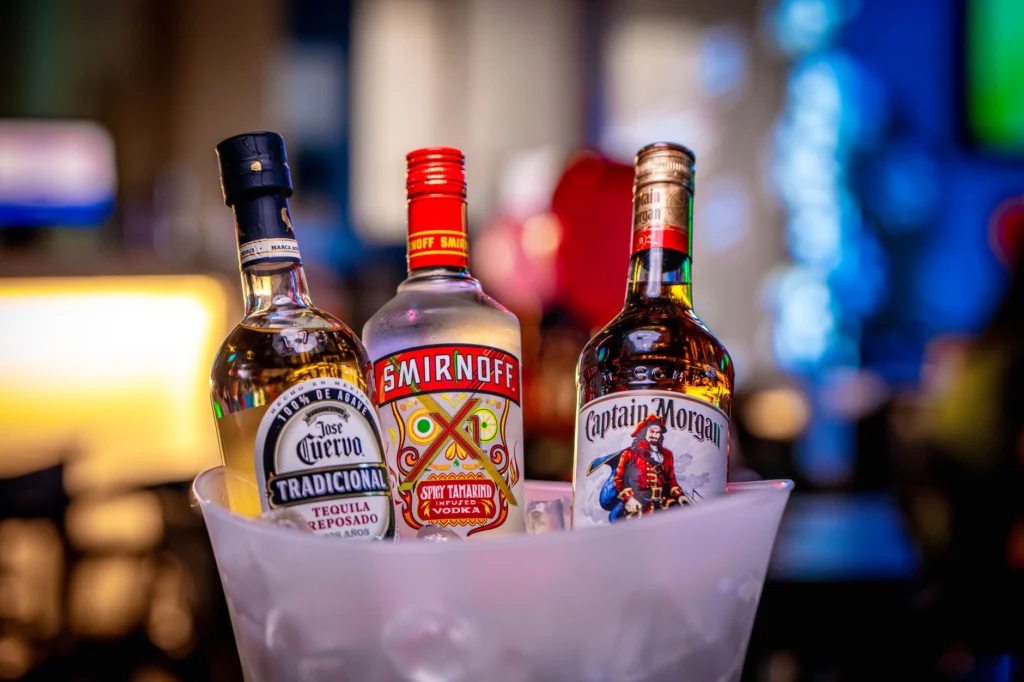 Vibrant shot of liquor bottles in ice bucket, perfect for bar themes.