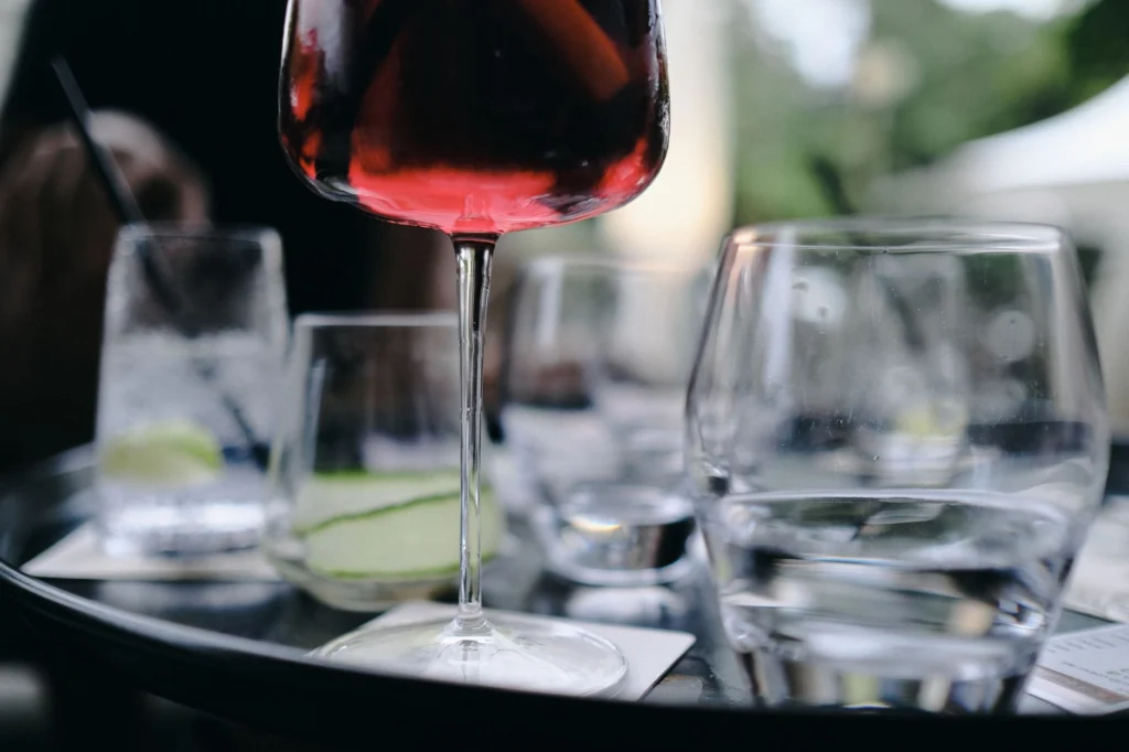 Close-up of red wine glass amidst elegant dining setup, perfect for luxury vibes.