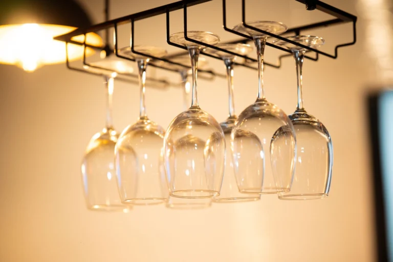 Stylish hanging wine glasses in a modern indoors setting with warm lighting and a minimalist design.