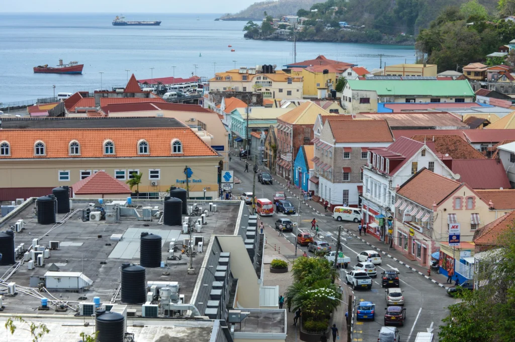 A vibrant aerial view of St. George's with colorful buildings, bustling street, and the scenic waterfront in Grenada.