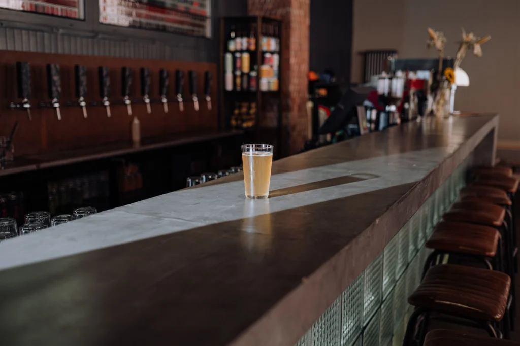 A refreshing glass of craft beer sits on a sleek bar counter, perfect for a modern pub setting.