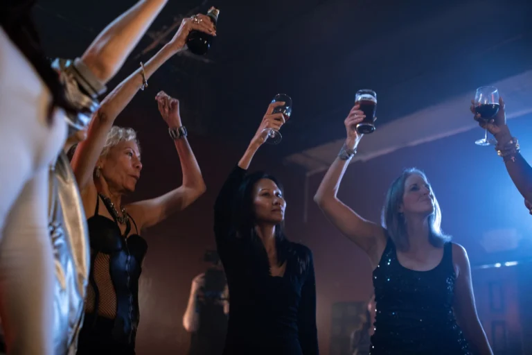 A lively scene of women raising glasses during a fun night out at a nightclub.
