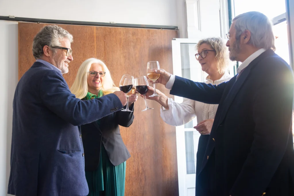 Senior adults raise wine glasses in a celebration indoors in Portugal, capturing a joyful and elegant moment.