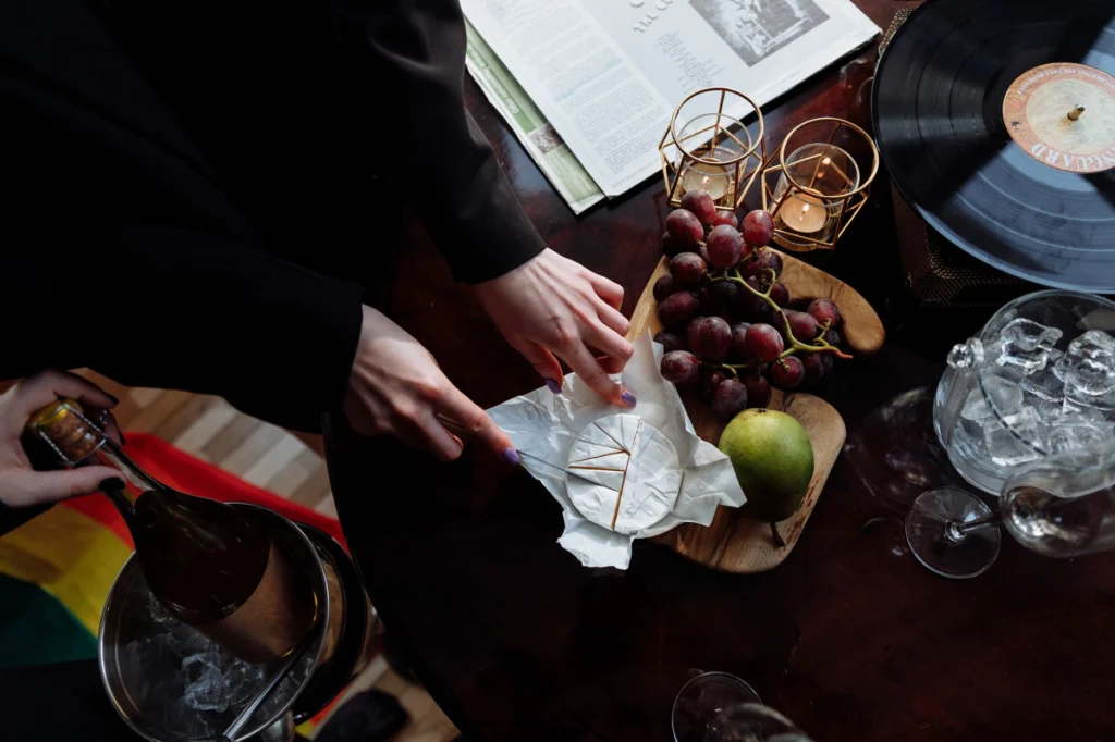 Top view of an elegant table setup featuring cheese, wine, and grapes, creating a cozy mood.