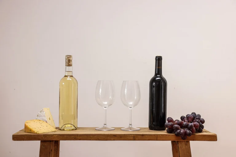 Elegant display of wine, cheese, and grapes on a rustic wooden table.